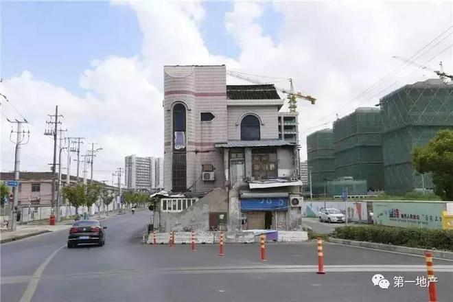 从涞寅路转至沪亭北路,一栋三层楼的房屋矗立在马路中央,让原本的四